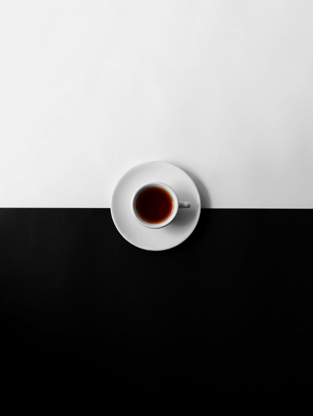 Cafecito — an espresso cup centered on a black and white split background